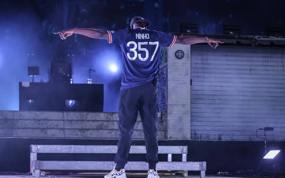 Ninho de dos sur scène, bras écartés, maillot floqué Ninho 357