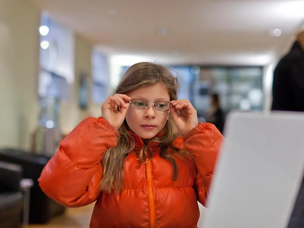 Petite fille ajustant ses nouvelles lunettes de vue