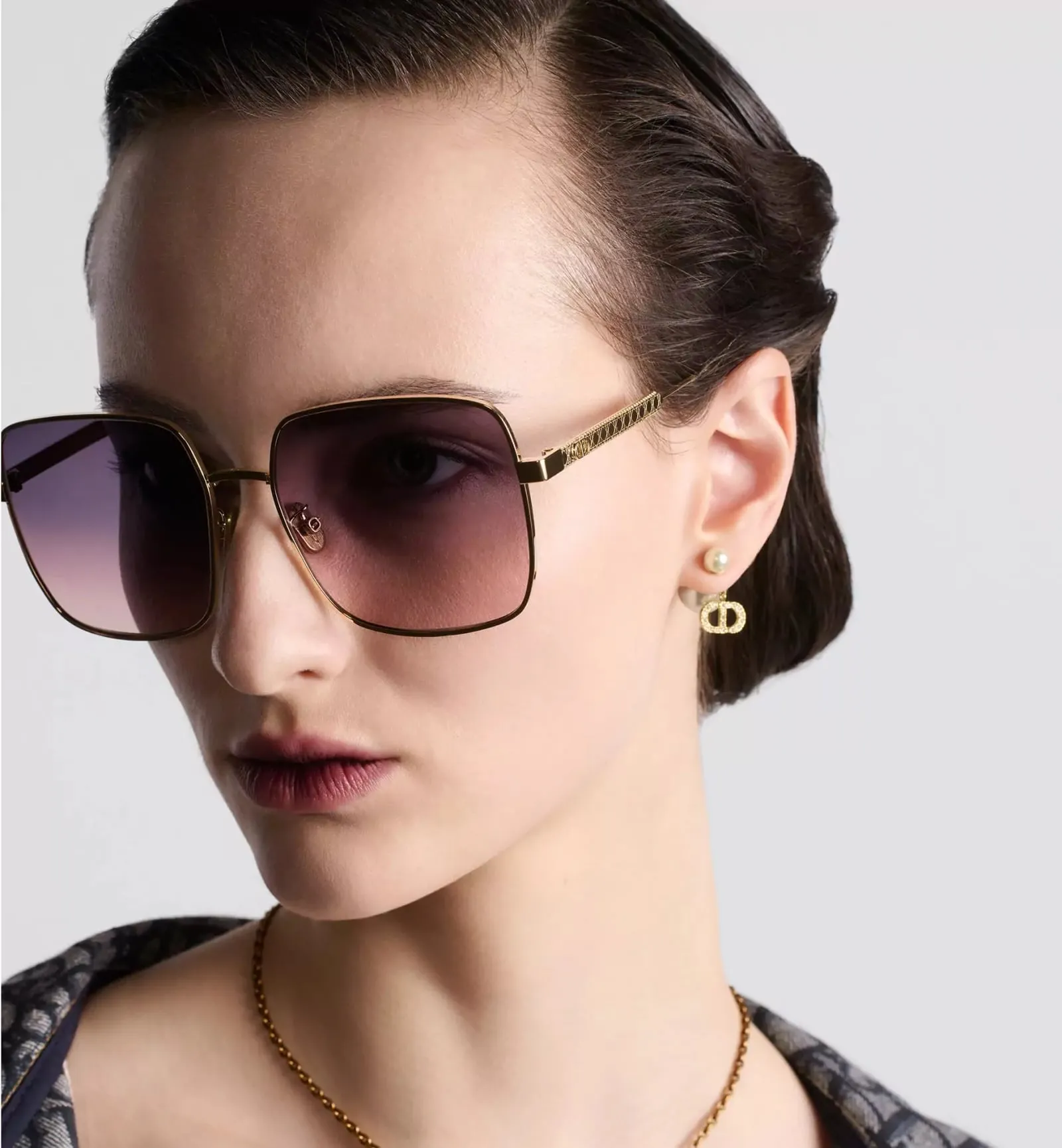 Femme portant des solaires Dior Cannage à verres dégradés violets
