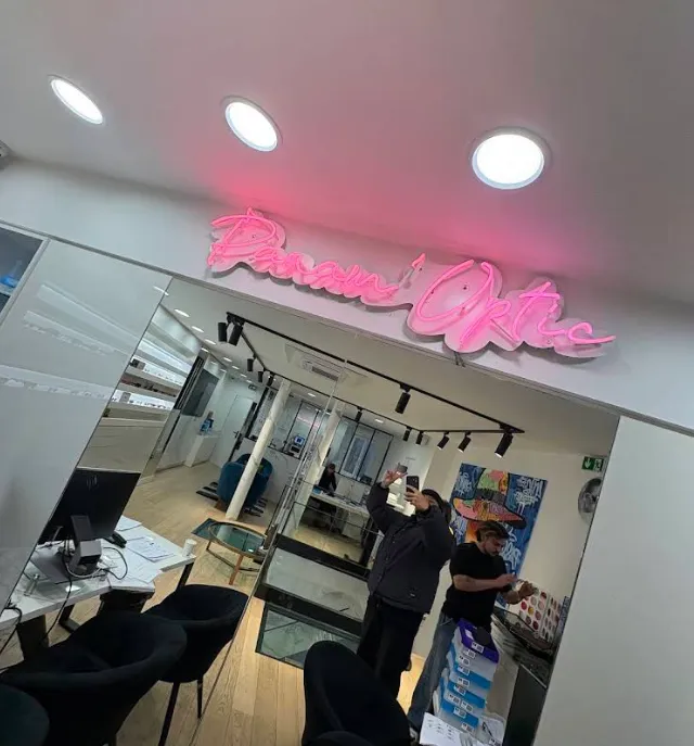 Enseigne néon rose Panam'Optic à l'entrée d'une boutique